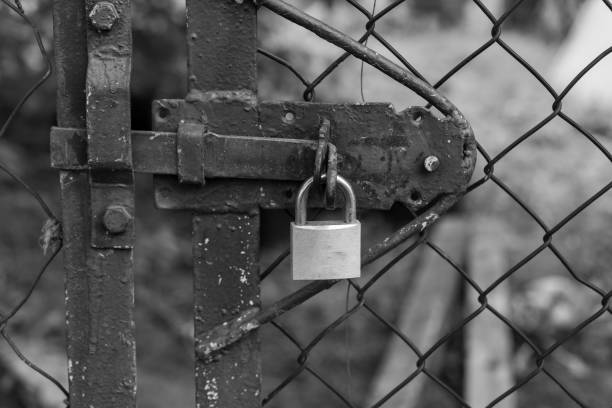 istock A padlock secures a metal gate with a chain-link fence 2180560365