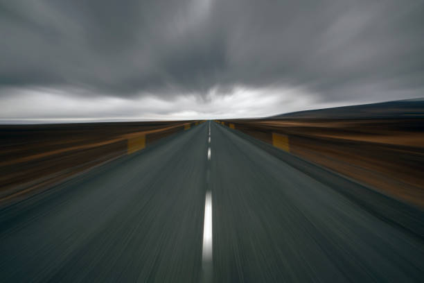 Blurred Iceland asphalt road and dark thunder clouds over it. High quality photo
