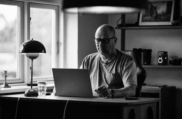 Man working over laptop on desk from home