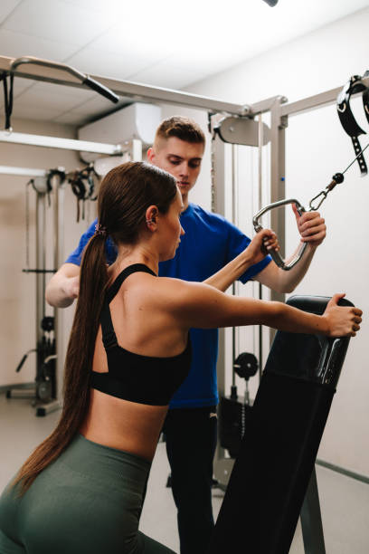istock Female patient is doing kinesitherapy yo improve physical conditioning. Assisted therapeutic gymnastics to strengthen muscles and rehabilitate injury. 2180566702