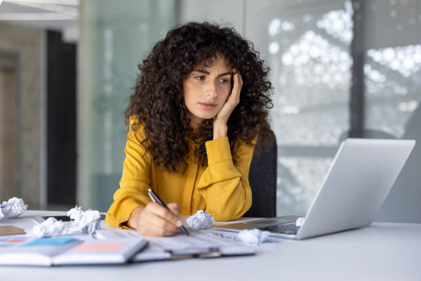 istock Hispanic businesswoman feeling stressed at work desk with laptop and documents in modern office setting 2180566872