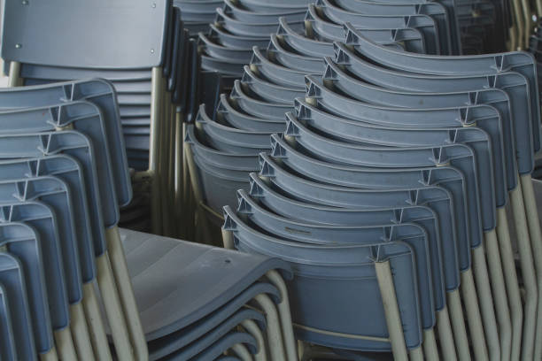 Group of cafeteria chairs stacked in the street.