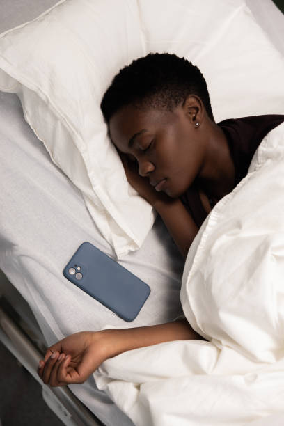istock Relaxed African patient in hospital asleeps with phone on pillow rests after difficult operation 2180572928