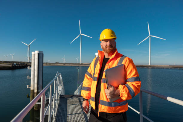 istock An engineer during his daily duties at a waterside windmill turbine power site 2180576843