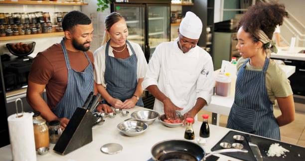 istock Cooking, class and chef in kitchen with meat preparation, teaching gourmet meal recipe or learning. Culinary course, people or mentor with lesson on food education or cuisine knowledge in hospitality 2180584749