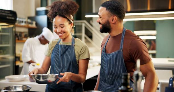 istock Cooking, cuisine and learning in kitchen, chef and team with skills, culinary or preparation of meal. Restaurant, apprentice and people with recipe, smile and talent in hospitality, students or apron 2180584759