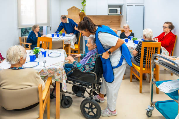 istock Nurse helping in a dining hall of a nursing home 2180585772