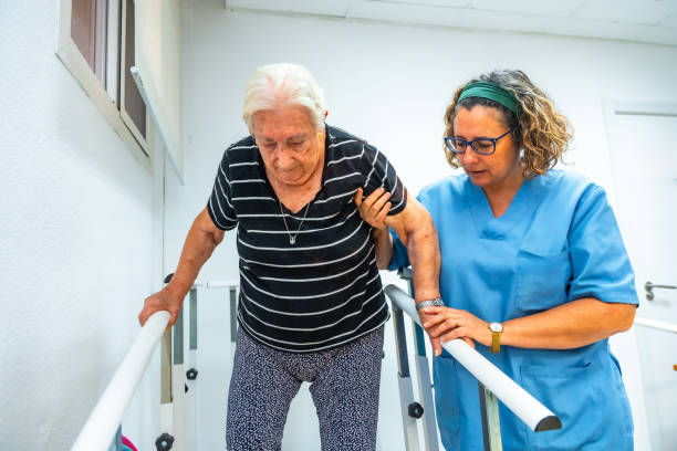 istock Physiotherapist helping a senior woman walking on parallel bars 2180585892