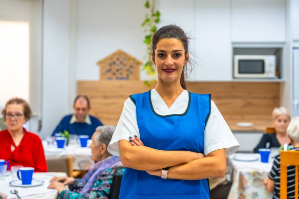 istock Confident caregiver standing proud at geriatrics dining room 2180586443