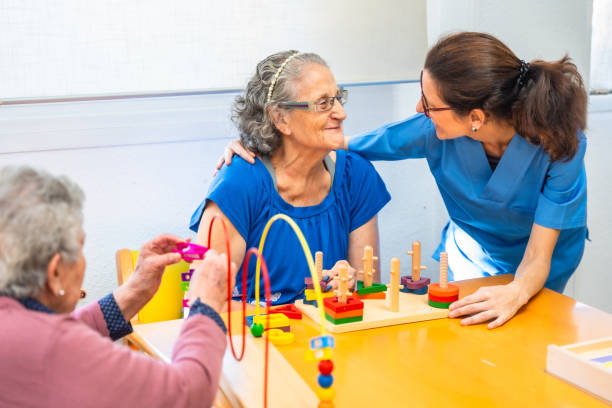 istock Tender caregiver assisting a senior woman while playing skill games 2180586894