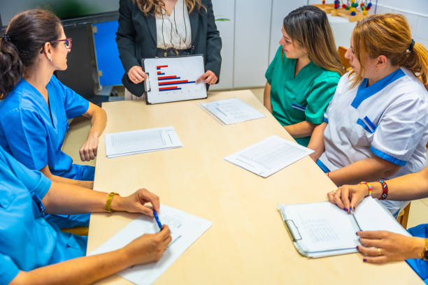 istock Manager of geriatric showing graphs and data to nurses team 2180586988