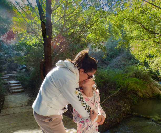 istock mother and daughter with loving gestures while enjoying a walk in the forest 2180593633
