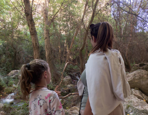 istock mother and daughter with loving gestures while enjoying a walk in the forest 2180593639