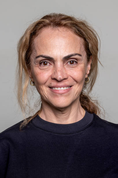 smiling mature hispanic woman looking at the camera on a gray background - brazilská etnická příslušnost fotky - stock snímky, obrázky a fotky