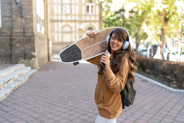 istock Young urban woman with a skateboard. 2180600567