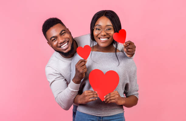 istock Cheerful afro couple holding red valentines cards 2180602111