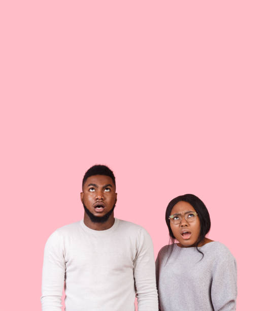 istock Stunned afro couple looking up at copy space 2180602136