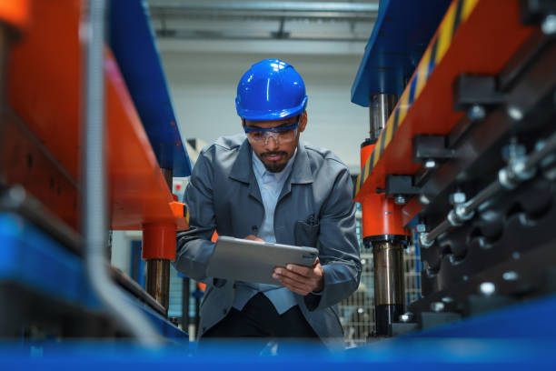 istock African American engineer with a blue helmet doing factory machine inspection 2180607918