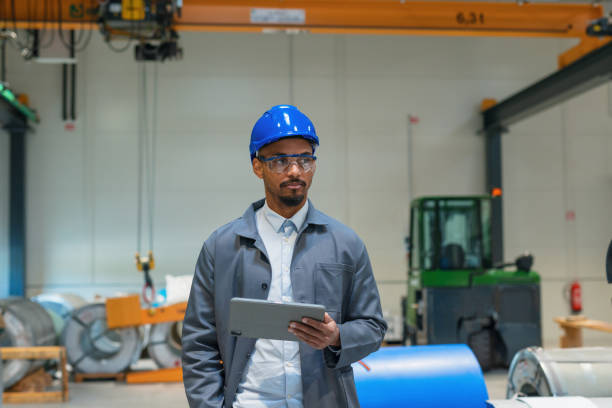 istock African American engineer walking through production line holding a tablet 2180608172