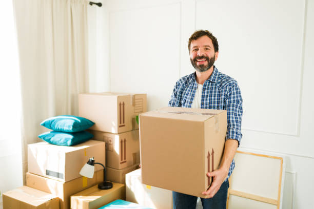 istock Joyful man happily moving a cardboard box into his new apartment, representing a fresh beginning full of anticipation and potential 2180613249