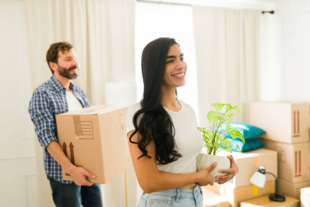 istock Excited couple moving into new home, unpacking boxes with love and support, starting fresh chapter together 2180613963