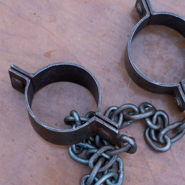istock Ancient iron shackles of a slave with a chain 2180616125