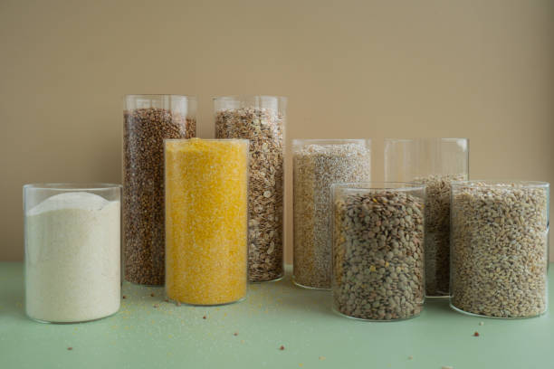 Refillable glass jar with raw grain porridge. Copy space Refill product format eco-friendly living. Filling reusable container Whole spelt grain species. High protein fiber-rich vegan plant based food ingredient. Gluten free superfood healthy nutritional dietary alternative food tarro de cristal recargable con gachas de cereales crudos. espacio de copia recarga formato de producto ecológico living. envase reutilizable de relleno especies enteras de grano de espelta. ingrediente alimenticio vegano de origen vegetal rico en fibra y