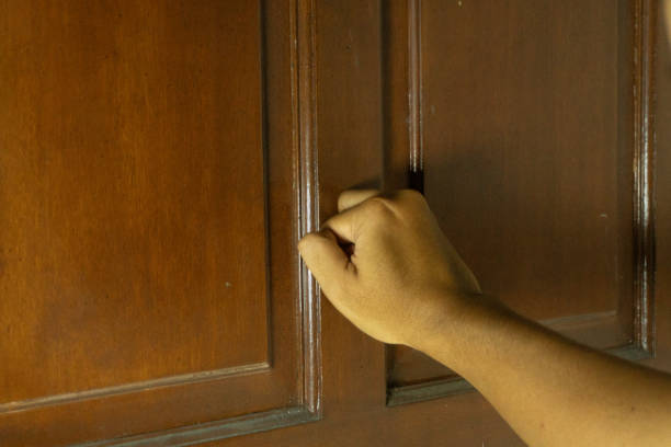 istock asian man's hand is knocking on the door 2180634857