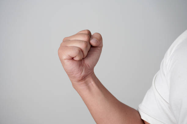 istock Male clenched fist, throwing punch, over grey 2180635697