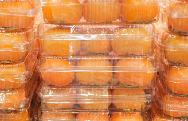 istock Persimmon in plastic boxes in the store close-up. 2180641333