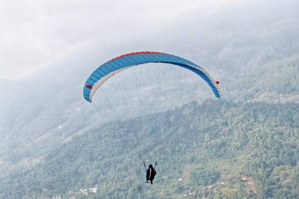 istock paraglider pilot fly in sky on beauty nature mountain landscape background 2180643095
