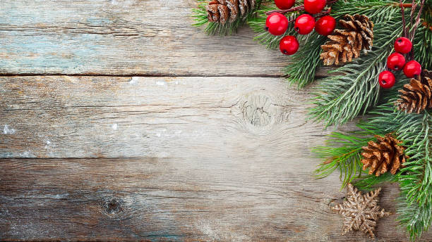 istock Christmas decorations on wood textured background with red berries, traditional decorations and dried pine cones with copy space 2180661405