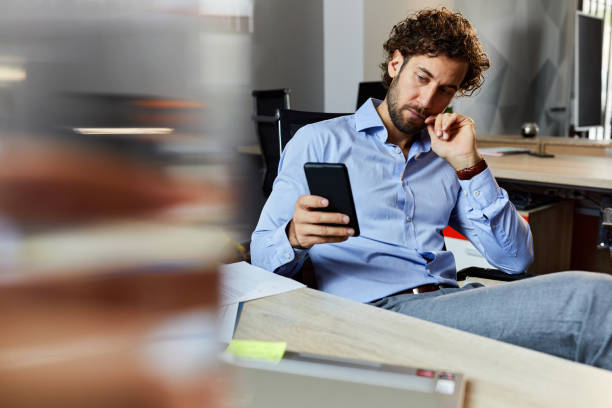 istock Young businessman using mobile phone in the office. 2180663535