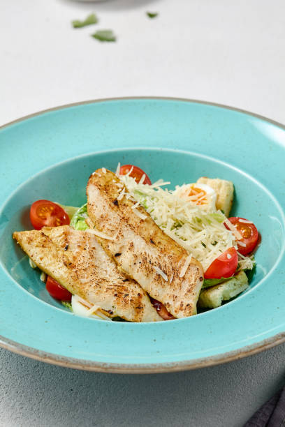 istock Vibrant Caesar Salad with Grilled Chicken Fillet in Turquoise Plate 2180664749