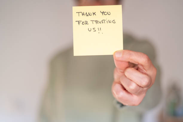 Business Person Holding Sticky Note With 'Thank You For Trusting Us! Message