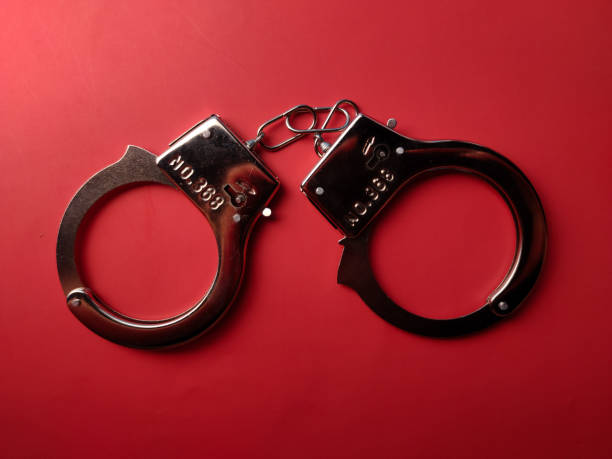 istock Top view metal hand cuff on a red background 2180671772