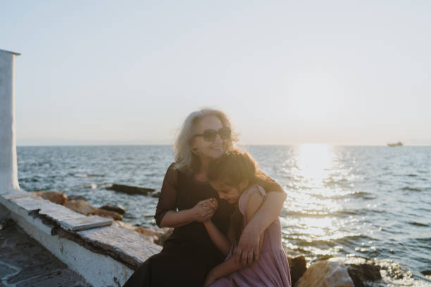 Photo that shows love between grandmother and granddaughter, who are sharing some love and affection on a promenade by the sea