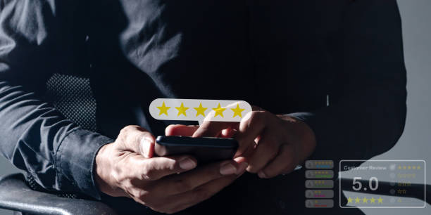 istock Customer Review, Young Man hand using smartphone mobile touch five star to review and give 5 stars with very good results in service, Good review 5 star rating choice feedback 2180673062