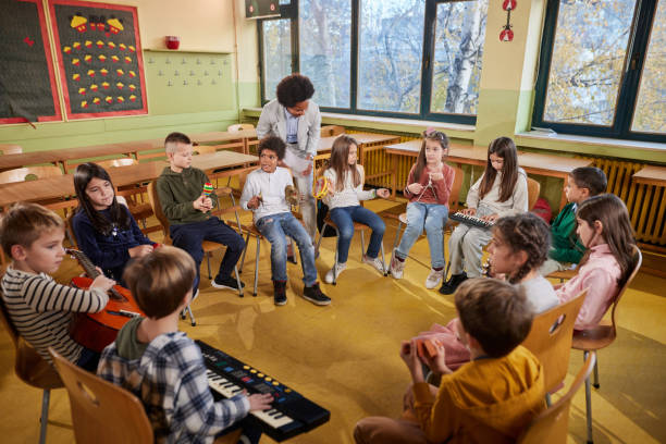istock Large group of elementary students having a music class with their teacher. 2180674301