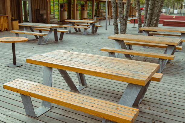 istock Empty picnic tables standing on a wooden deck 2180675665