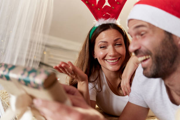 istock Happy couple relaxing on a bed during Christmas morning. 2180676464