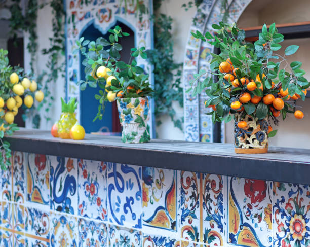 Branch with lemons, tangerines in ceramic vase on table. Traditional pattern, Sicily, Italy.