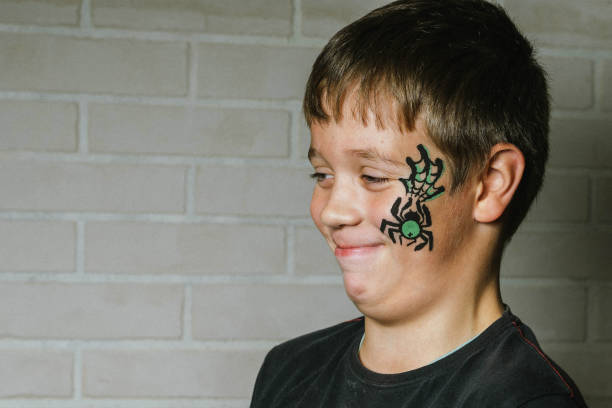 istock Boy smiling with spider face paint for party 2180679512