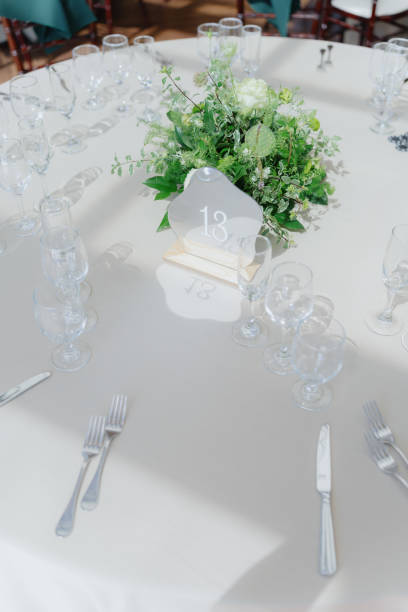 istock Elegant wedding table setup with a floral centerpiece and numbered place settings 2180679513