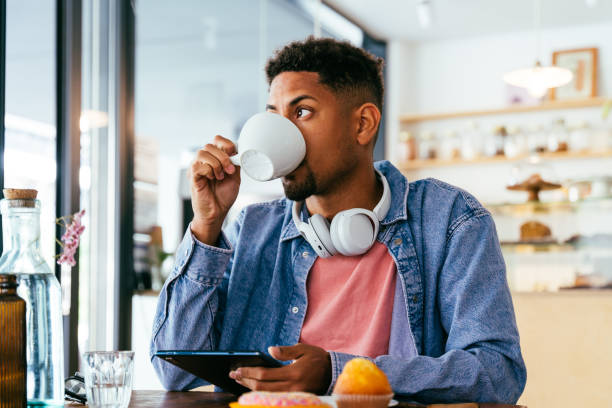 istock Handsome young hispanic man sitting in a bar cafeteria 2180679735