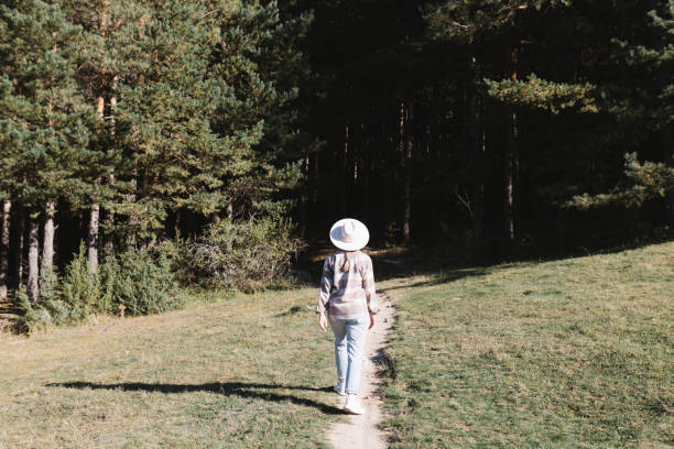 istock The woman goes through a beautiful pine forest. 2180682228
