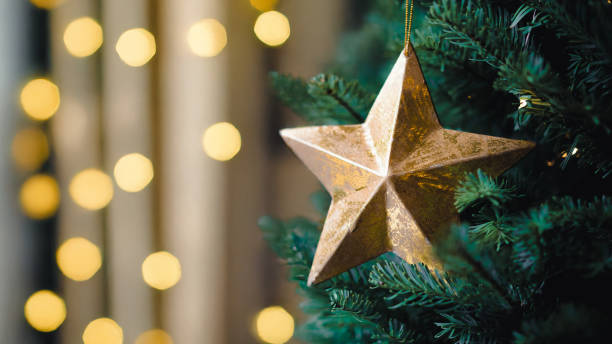 istock Gold star on Christmas tree with defocused background and bokeh lights. 2180682303