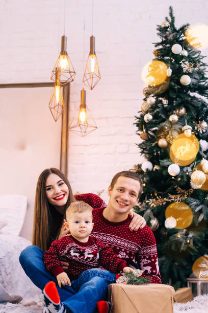 istock happy family looking into camera on Christmas tree background. f 2180683875