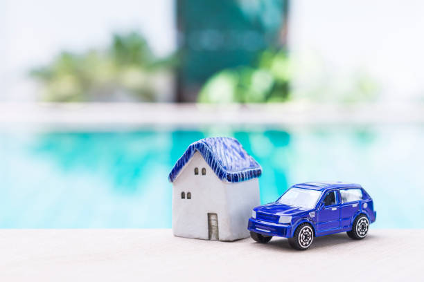istock Miniature house with blue car model over blurred swimming pool background 2180687810