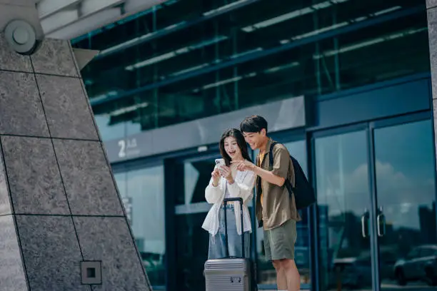 After walking out of the station, a traveler uses their smartphone to check information, ensuring they're on the right path to their destination. After walking out of the station, a traveler uses their smartphone to check information, ensuring they're on the right path to their destination.